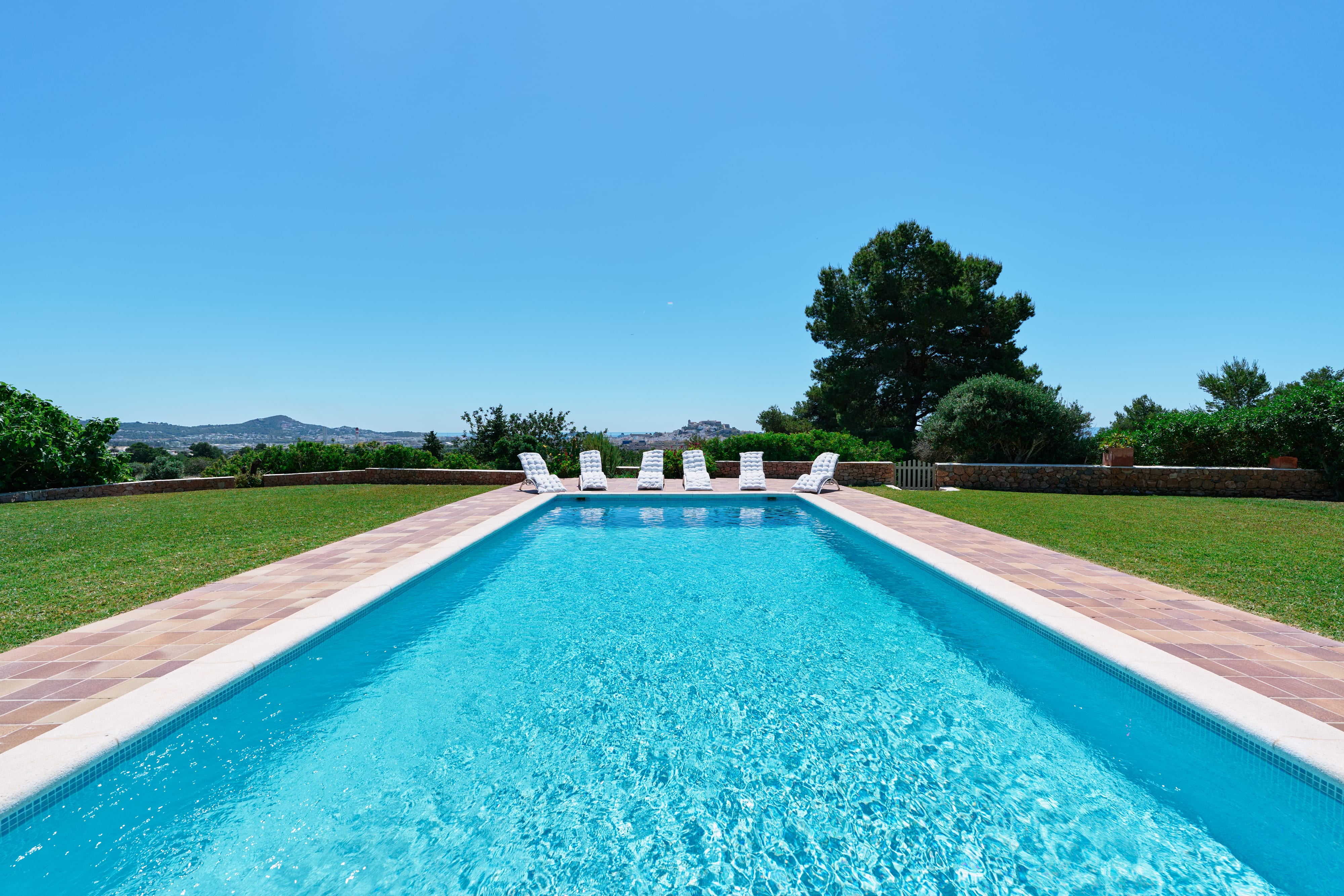 Piscina rectangular con tumbonas