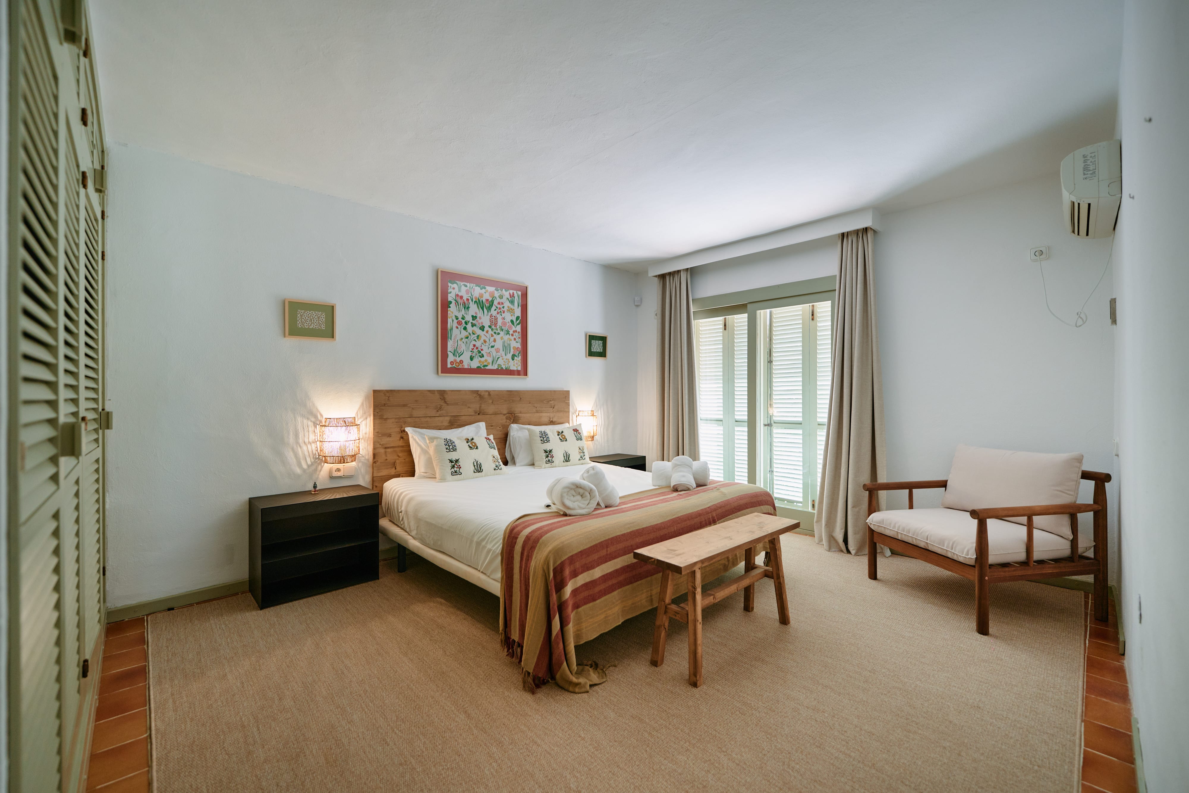 Dormitorio con cama doble y puerta al jardín
